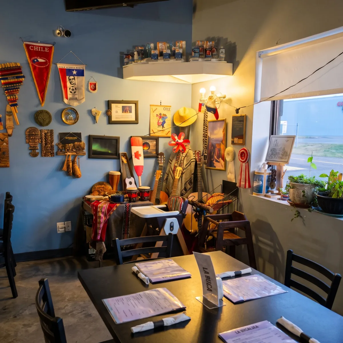 La Boca Loca dining room by the window with pennants, plants and wall decor